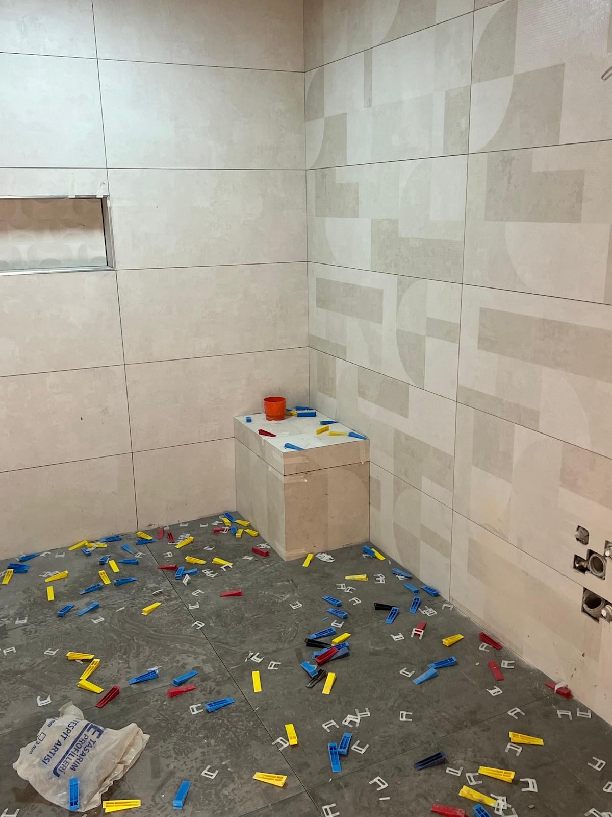 Banyo duvarında seviyeleme klipsi ile seramik döşeme aşaması